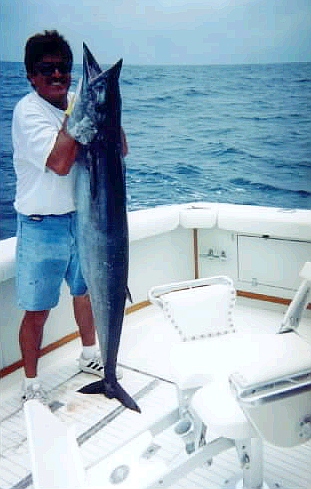 First Mate LUCAS PERALTA checking for tonsils on this beautiful wahoo caught on CABO MAGIC.